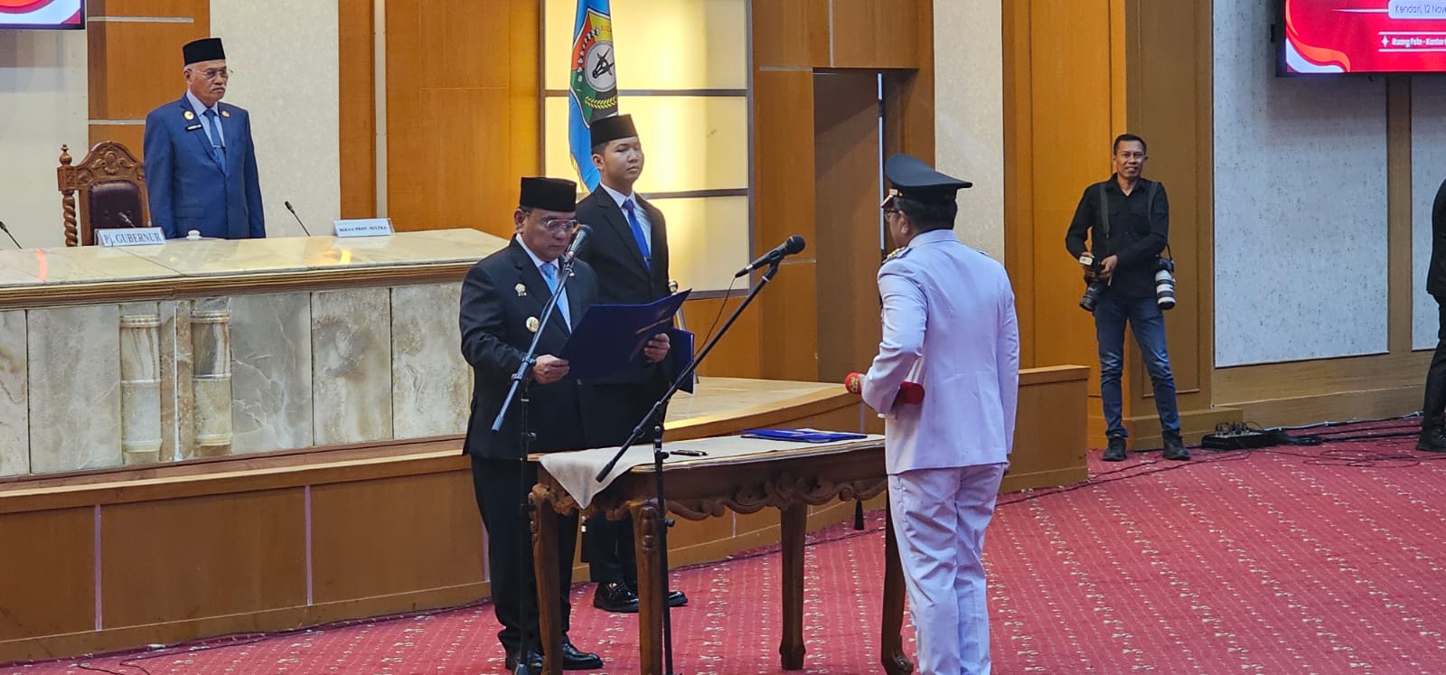 Pj Gubernur Sultra, Andap Budhi Revianto (kiri) saat melantik dan mengambil sumpah jabatan Ridwan Badallah sebagai Pj Bupati Buton Selatan. (Foto: Ist/KR)